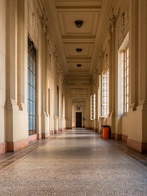Corredor do Palácio Tiradentes, com janelas altas e piso de mosaico.